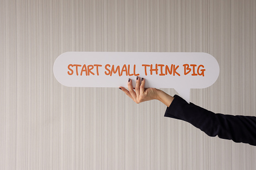 Woman Holding Speech Bubble With Start Small Think Big Message