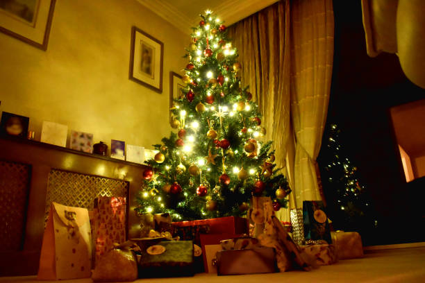 istock Beautiful Decoration Christmas tree with presents and gift boxes bright light in the cozy living room, decoration on Christmas holiday in the UK. 1733988730