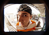 Fish eye shot of young serious male hip hop dancer in headband looking at camera