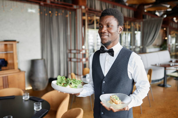 istock Young Black man bringing food on tray in restaurant 1734020049