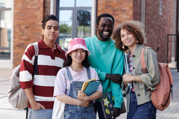 istock Diverse group of students smiling at camera outdoors on college campus 1734030312