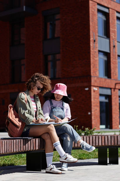 istock Two young female students working on project together outdoors in college campus 1734030313