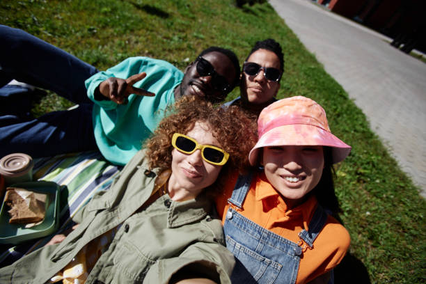 istock Young people taking selfie outdoors relaxing on grass in sunlight 1734030628