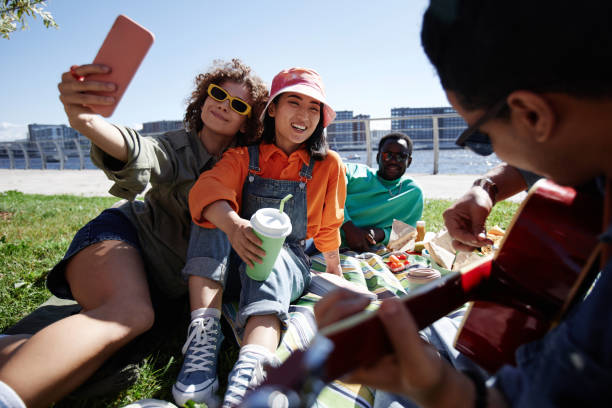 istock Multiethnic group of young people taking selfies outdoors enjoying picnic 1734030656