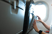 Adult woman hands open food tray in front of airplane seat while traveling