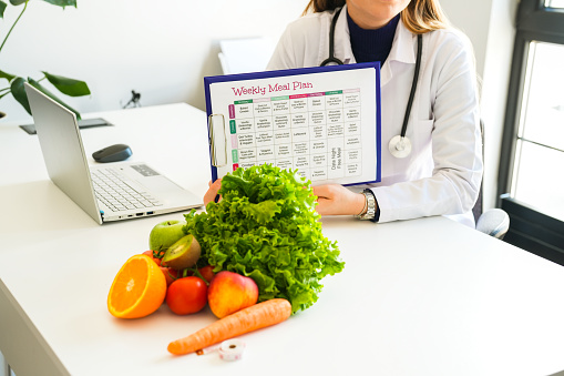 Healthy nutritionist holding a diet list, face not visible