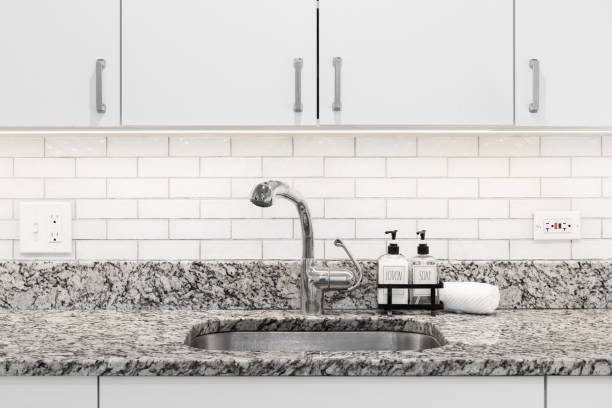 istock A faucet detail with white cabinets and tile backsplash. 1734071754