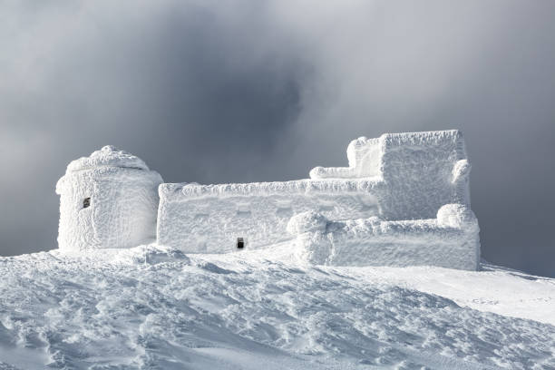 istock Winter scenery. A panoramic view of the old observatory covered with textured snow. Beautiful landscape of high mountains, foggy sky. Lawn covered with white snow. Wallpaper snowy background. 1734106469