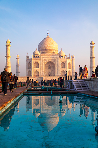 3rd February, 2020 - Agra, India: An early morning shot captures the Taj Mahal bathed in the soft, warm glow of the rising sun. The absence of haze allows for a clear and vivid representation of this iconic structure, accentuating its intricate marble inlay and grandiose architecture. Tourists and visitors in the image are seen admiring the monument, their attention captivated by its beauty and the exceptional lighting conditions. This UNESCO World Heritage site, built between 1632 and 1648, serves not only as a testament to undying love but also as a pinnacle of Mughal art and architecture.