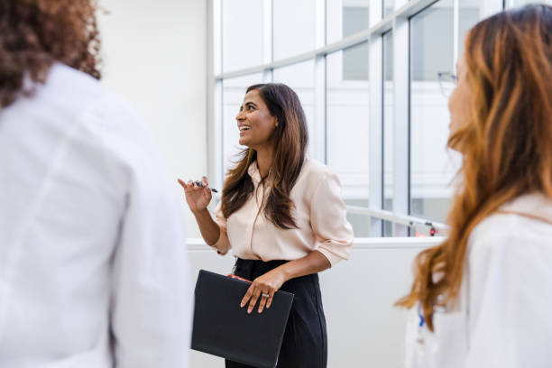 istock Female hospital administrator gestures while talking with the unrecognizable medical staff 1734158912