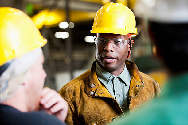 afro americano uomo in un cappello duro giallo - construction worker manufacturing occupation occupation meeting foto e immagini stock