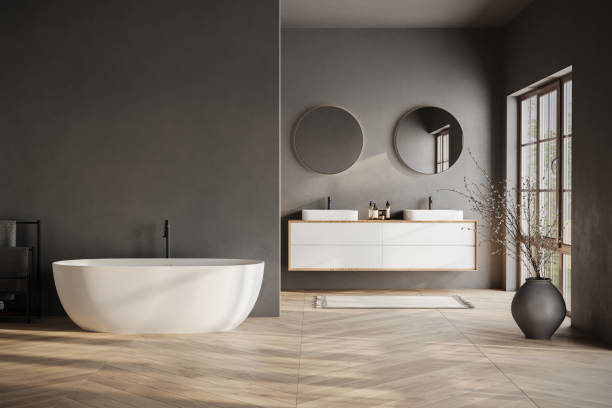 istock Modern bathroom interior with dark walls, marble basin with double mirror, bathtub, parquet floor. Minimalist black bathroom with modern furniture 1734198484