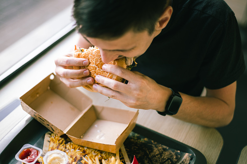 Professional chef made gourmet fish hamburger in take away boxes close up.