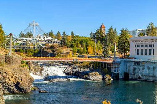 View of Riverfront Park, with the pavilion and clock tower in view rising above the Spokane River, the Upper Falls district, and Post Street Bridge in downtown Spokane, Washington, USA. The Spokane River is about 110 miles long and stretches from Lake Coeur d'Alene to Lake Roosevelt. The Upper Spokane Falls are located in downtown Spokane. They are the second largest urban falls in the country. There are many footbridges and walking paths located around the falls for various views and easy access.