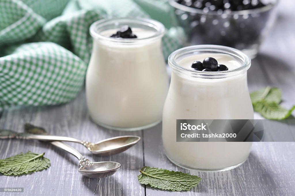 yogurt with fresh blueberry yogurt with ripe fresh blueberry in jars on wooden background Jar Stock Photo