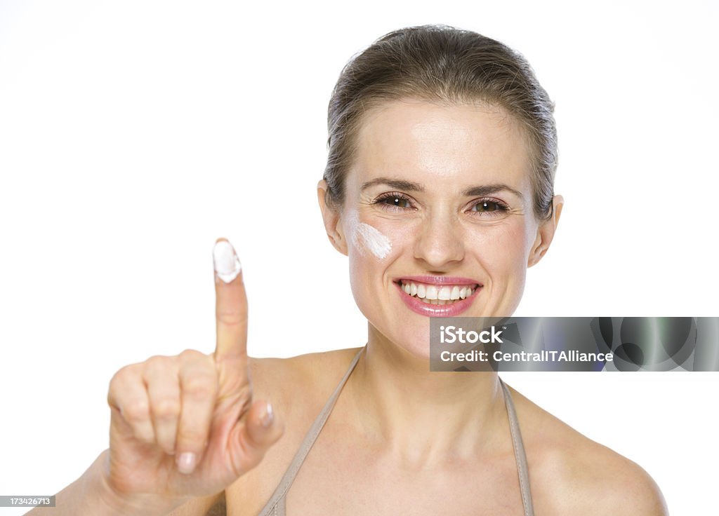 Beauty portrait of happy young woman showing creme on finger Adult Stock Photo