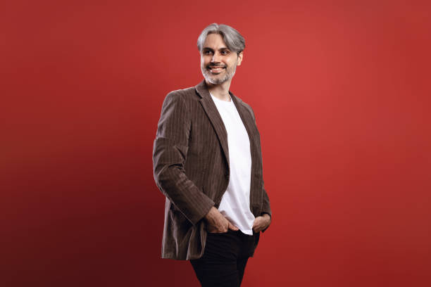 istock man smiling with hands in pocket and looking to the side 1734273896