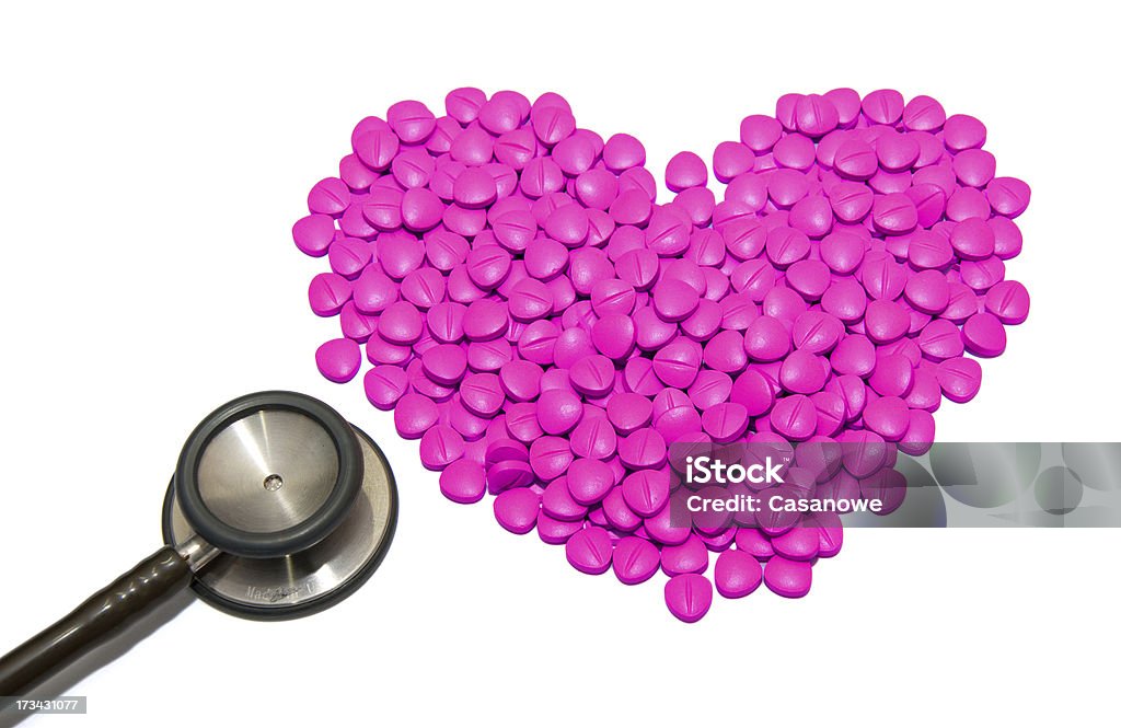 Estetoscópio médico com cor-de-rosa em forma de comprimidos drogas - Foto de stock de Branco royalty-free