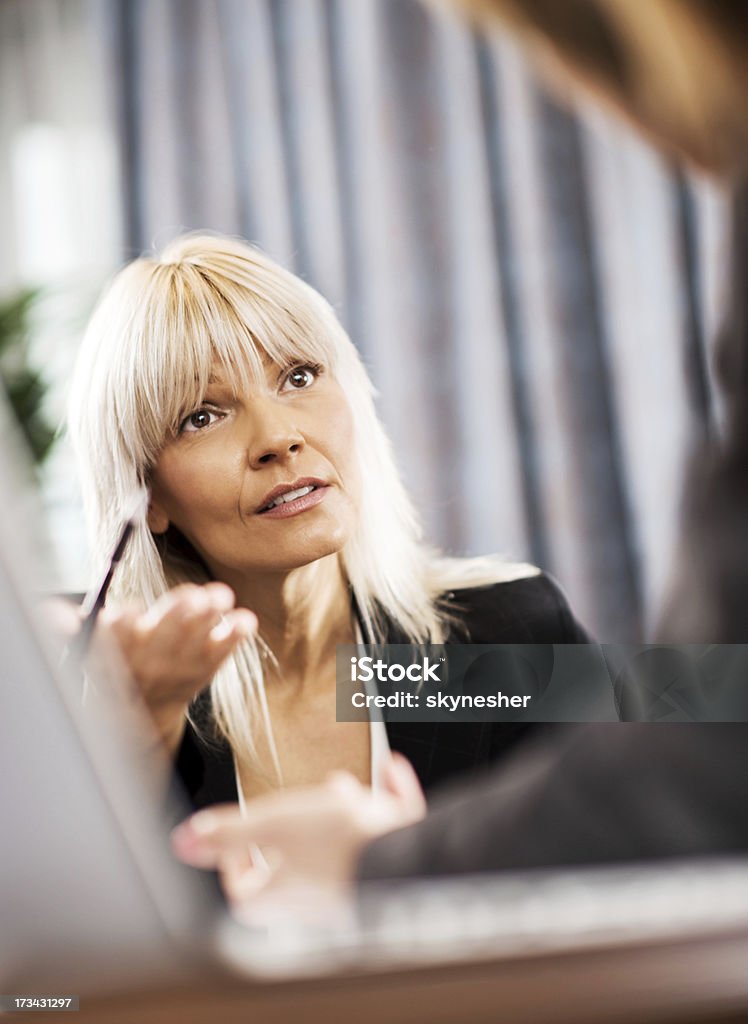 Business discussion. Women on a business meeting. Focus is on a blonde business woman who is explaining something to her colleague.    30-39 Years Stock Photo