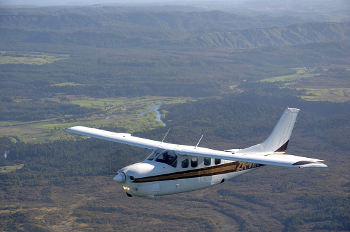 Greymouth, New Zealand, September 19, 2009: A Cessna 210 light aircraft flying over Westland, New Zealand