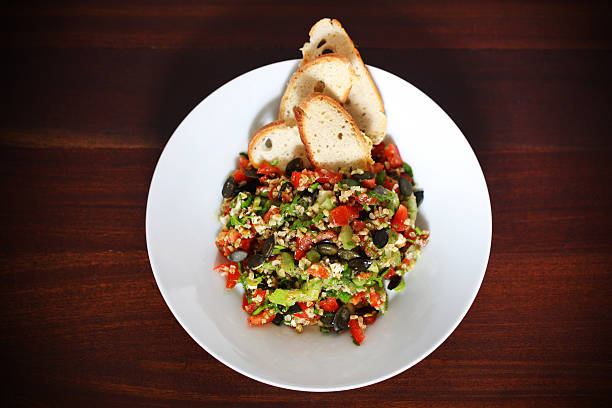 Tabbouleh salad with bulgur wheat, tomatoes, olives and crackers, traditional arabic