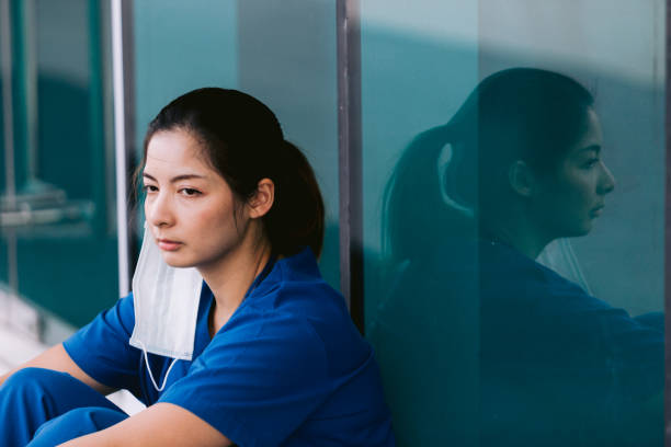 istock Stressed tired healthcare worker sitting on floor 1734385544