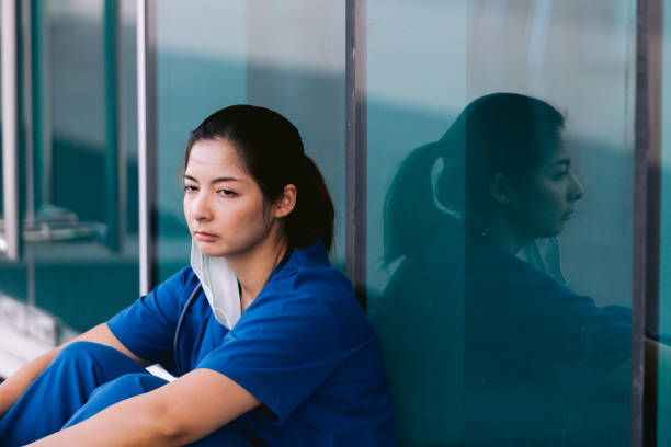 istock Stressed tired healthcare worker sitting on floor 1734385548