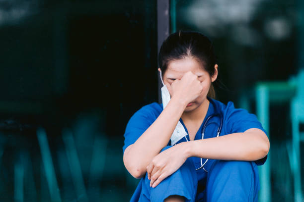 istock Stressed tired healthcare worker sitting on floor 1734385549