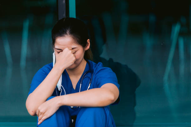 istock Stressed tired healthcare worker sitting on floor 1734385551