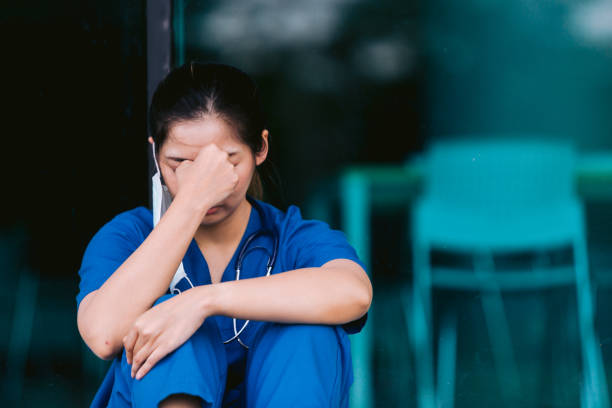 istock Stressed tired healthcare worker sitting on floor 1734385552