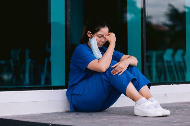 istock Stressed tired healthcare worker sitting on floor 1734385556