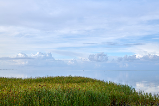 Lake Garda (Lago di Garda) in front of the small village of Lazise, tourist resort in Verona province, Veneto, Italy, Europe. On the horizon the coastline of Lombardy.