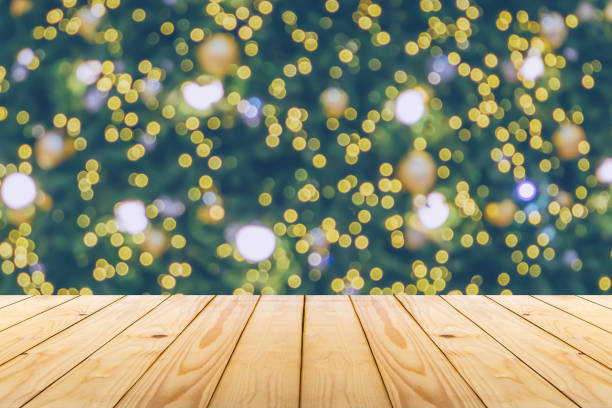 istock Empty wood table top with blur Christmas tree with bokeh light background 1734389435