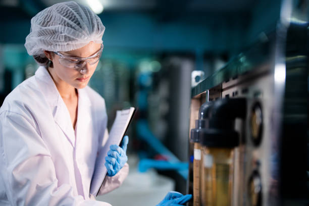 istock scientist worker checking the quality of Reverse osmosis machine system at the industrial factory. Female worker recording data at the control panel with measure pressure for recycle portable plant. 1734396069
