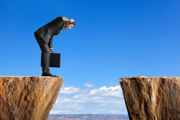 istock Man in a suit stares at space between two ledges 173443511