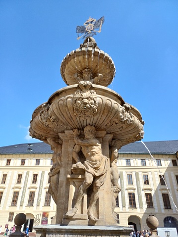 Prague, Czech Republic - June 9, 2023: Fountain in the courtyard of Prague Castle with sunny day, blue sky in background.