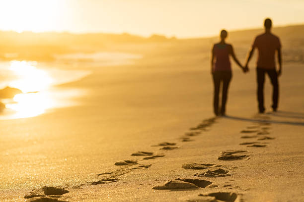istock Footprints Of Couple Walking On Beach At Sunset 173444377