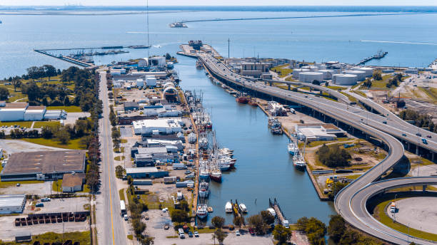 Entrance to the Hampton Roads Bridge-Tunnel near marina in Hampton News, Virginia, in sunny day. Aerial view Newport News, VA marina port adorned with yachts and cargo ships. Hampton Roads Beltway lead to waterfront british commonwealth stock pictures, royalty-free photos & images