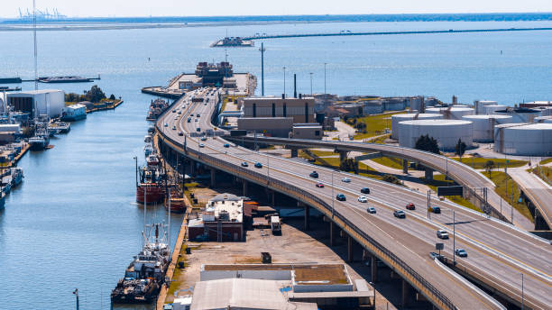 Hampton Roads bridge-tunnel entrance line industrial zone in Virginia. Oil and gas storage along the road in marina of Newport News, VA Newport News, VA marina port with yachts and ships. Hampton Roads Beltway lead to waterfront british commonwealth stock pictures, royalty-free photos & images