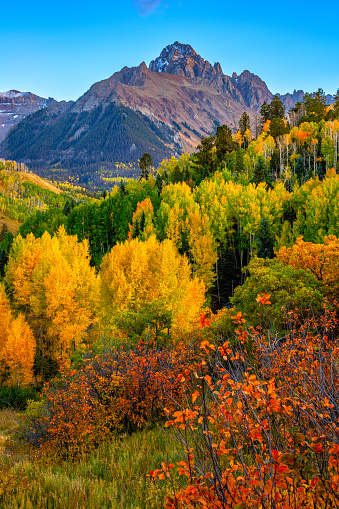 The peak of Mt. Sneffels at 14,157 feet, the highest peak in Sneffels region of the southwest Rocky Mountains, shot in early autumn with the fall colors highlighted by the sun.