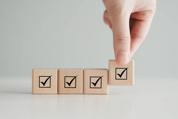 istock Checklist, Task list, Survey and assessment, Quality Control, Goals achievement and business success. Vote, to do list, Hand holding check mark on wooden block to complete checklist. 1734520133