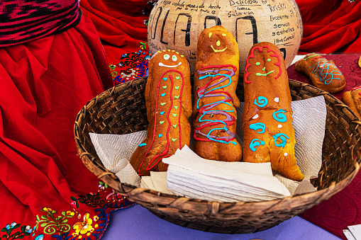 Cuenca, Ecuador - October 30, 2022: Day of the Dead event. The bread Guagua or bread figure and the drink Colada Morada in a large ceramic pot with the name on it. Breads made in the shape of a baby.