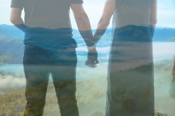 istock Double Exposure, man and woman standing holding hands and a complex mountain view. 1734576062