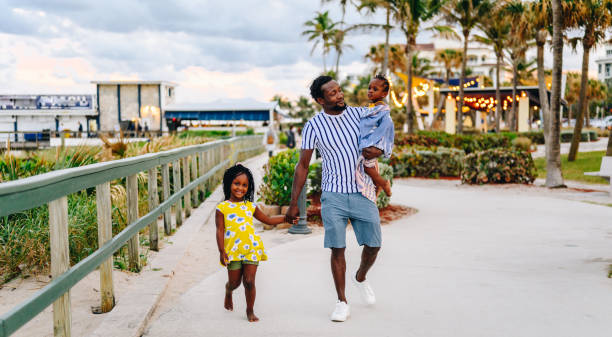 istock African American father with two young daughters walks on a beach boardwalk with his cute children on vacation 1734613992