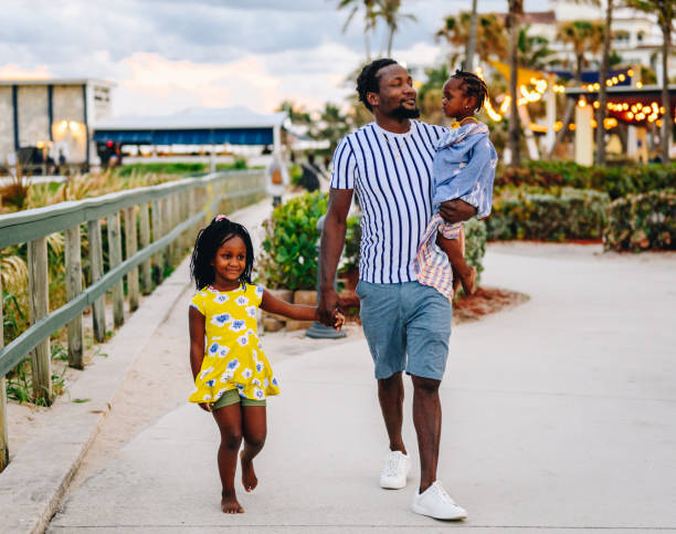 istock African American father with two young daughters walks on a beach boardwalk with his cute children on vacation 1734615086