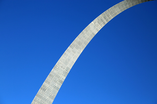 Grass, water and autumn trees surround the Gateway Arch in Saint Louis, Missouri.