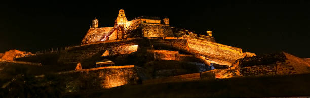 vista panorámica por la noche al iluminado castillo de san felipe de barajas, cartagena, colombia - castillo de san felipe de barajas fotografías e imágenes de stock