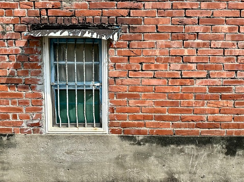 Photo of old house window with brick walls