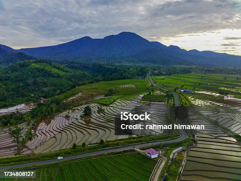 istock aerial view of Indonesia in beautiful mountain and agricultural areas during clear weather, with blue mountains, wide stretches of green grasslands and beautiful yellowing rice 1734808127