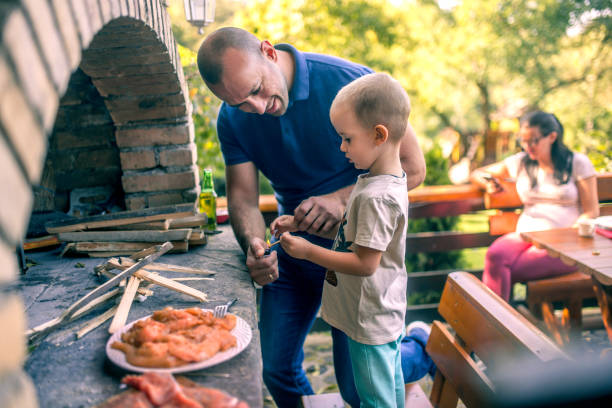 istock Dad is preparing a barbecue with his son in the yard 1734818302